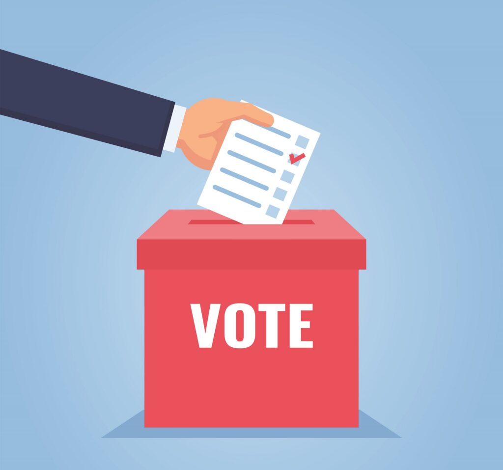 A cartoon showing a hand dropping a ballot into a vote box